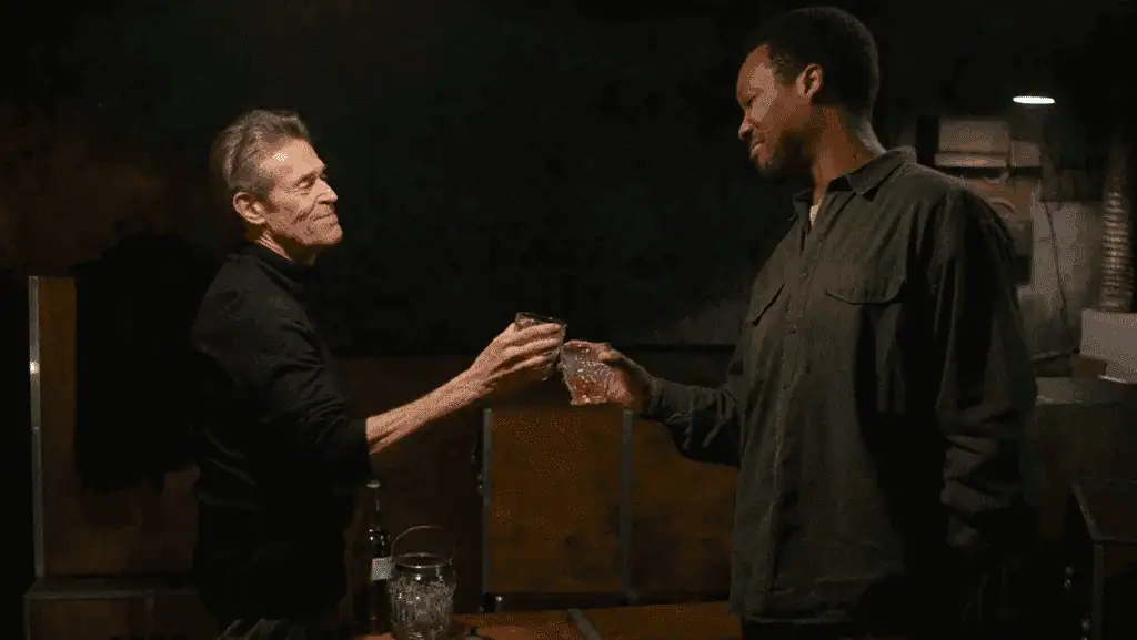 Two men exchanging a drink in a dimly lit setting, symbolizing connection and storytelling.